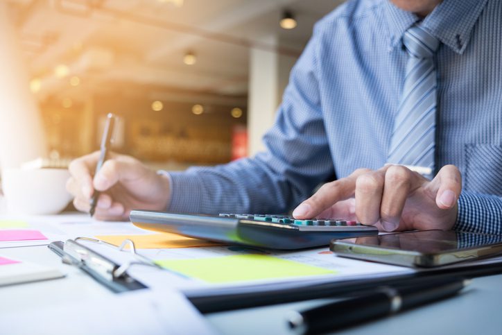 Martinson & Carter, CPAs, PA | business man holding a pen and working on a calculator at his desk